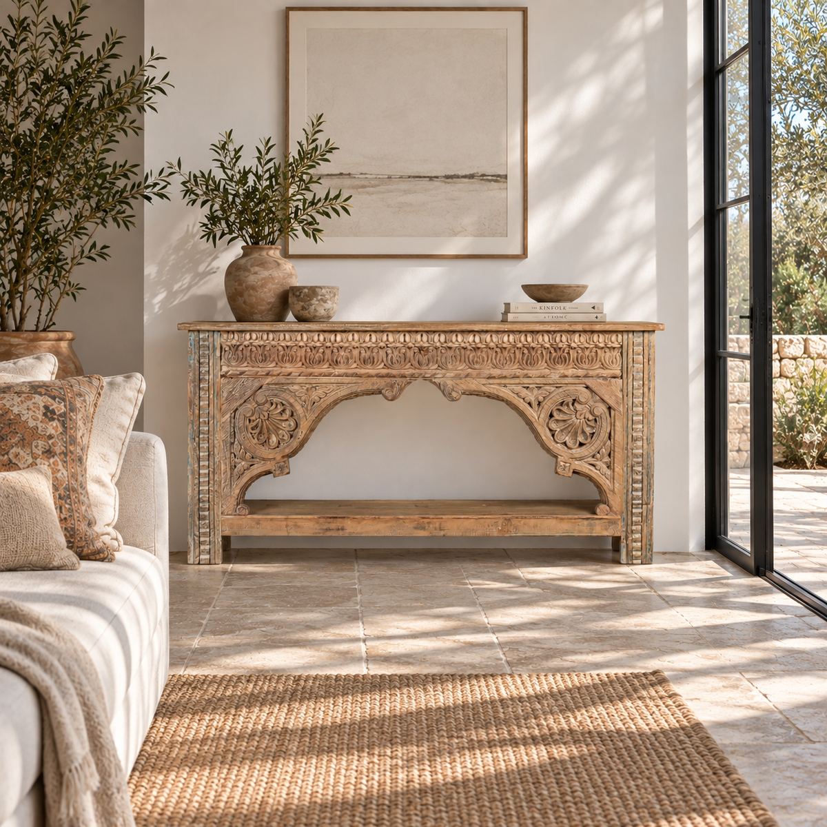 Lifestyle image of a Ruhan reclaimed teak wood console table with hand-carved Indian architectural front and open storage shelf 171cm