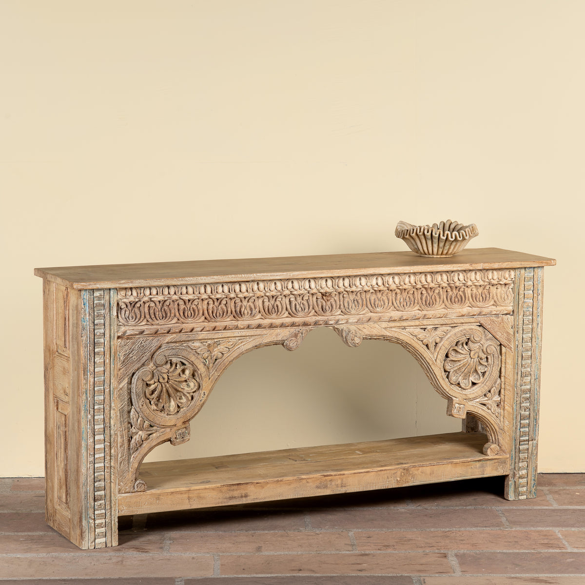 Side angle image of a Ruhan reclaimed teak wood console table with hand-carved Indian architectural front and open storage shelf 171cm
