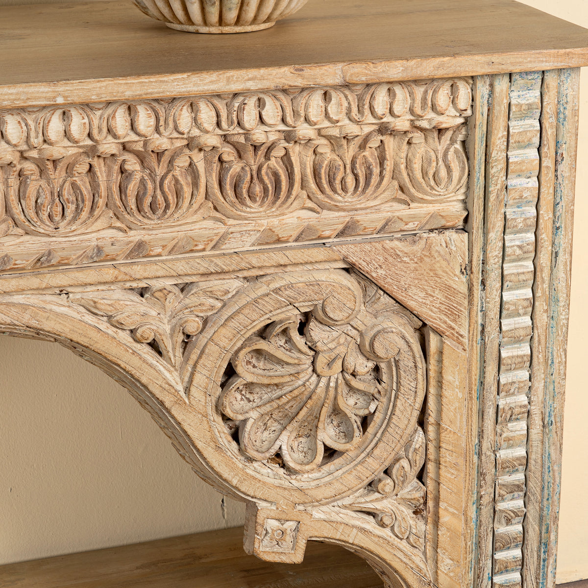 Close up image of a Ruhan reclaimed teak wood console table with hand-carved Indian architectural front and open storage shelf 171cm