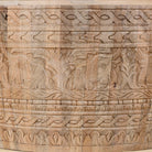 Close up image of a hand-carved mango wood coffee table with intricate botanical and geometric carvings.