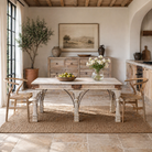 Lifestyle image of a teak wood dining table with six hand-carved pillar legs; reclaimed Indian dining table, 180 × 90 × 75 cm.