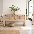 Lifestyle image of a reclaimed teak wood console table with hand-carved floral fronts and iron accents; sustainable furniture, 153 × 80 × 40 cm.