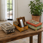 Lifestyle image of a hand-painted wooden jewellery box Manan with floral motifs and foldable mirror. A vintage home accessory and unique Indian decoration ideal for vintage home decor and storing jewellery or keepsakes.