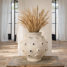 Lifestyle image of a handmade papier-mâché vase Barfi with dotted surface and mirrored details. A vintage home accessory and unique Indian decoration ideal for dried flowers or as a sculptural piece in vintage home decor.