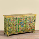 Side angle image of a Ruturaj hand painted reclaimed Indian teak wood chest with colourful floral motifs and iron fittings 150cm
