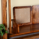 Close up image of the seat of a Rutvi mango wood swing bench with stand, rattan backrests and folding coffee table, 237cm