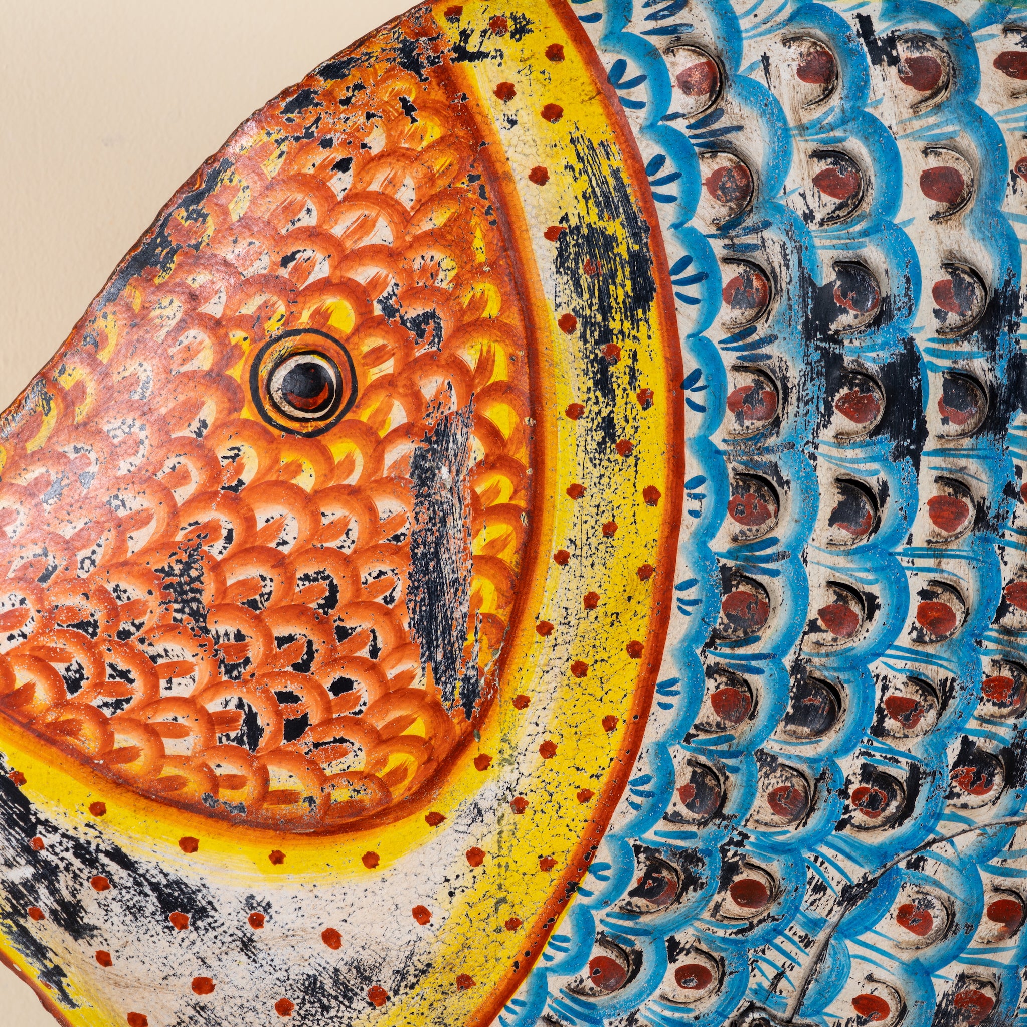 Close up image of a Saatvik hand painted freestanding metal fish sculpture with vibrant blue, orange and yellow detailing, handcrafted decorative home accessory, 107x15x80cm.