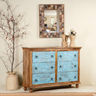 Side angle image of a hand-carved mango wood chest of drawers Safita with distressed blue finish and iron fittings, boho style living room furniture, 140 × 42 × 100 cm.