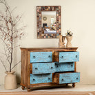 Image with open drawers of a hand-carved mango wood chest of drawers Safita with distressed blue finish and iron fittings, boho style living room furniture, 140 × 42 × 100 cm.