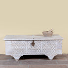 Samay mango wood storage chest coffee table with carved geometric front, iron fittings, wooden wheels and distressed finish 120cm