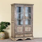 Side angle image of a of a hand-painted display cabinet Sambalpur made from recycled wood with glass doors – sustainable furniture featuring Sanskrit motifs and traditional Indian craftsmanship.