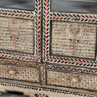 Close up image of a of a hand-painted display cabinet made from recycled wood with glass doors – sustainable furniture featuring Sanskrit motifs and traditional Indian craftsmanship.