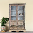 Lifestyle image of a of a hand-painted display cabinet made from recycled wood with glass doors – sustainable furniture featuring Sanskrit motifs and traditional Indian craftsmanship.