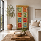 Lifestyle image of a hand-painted sustainable teak wood cabinet with floral motifs – Sangrur by Om Home & Garden, a one-of-a-kind piece of sustainable furniture with artistic expression.