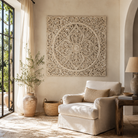 Lifestyle image of a whitewashed hand-carved mango wood wall panel with intricate floral and ornamental engravings, designed as elegant wall décor or a decorative bed panel.