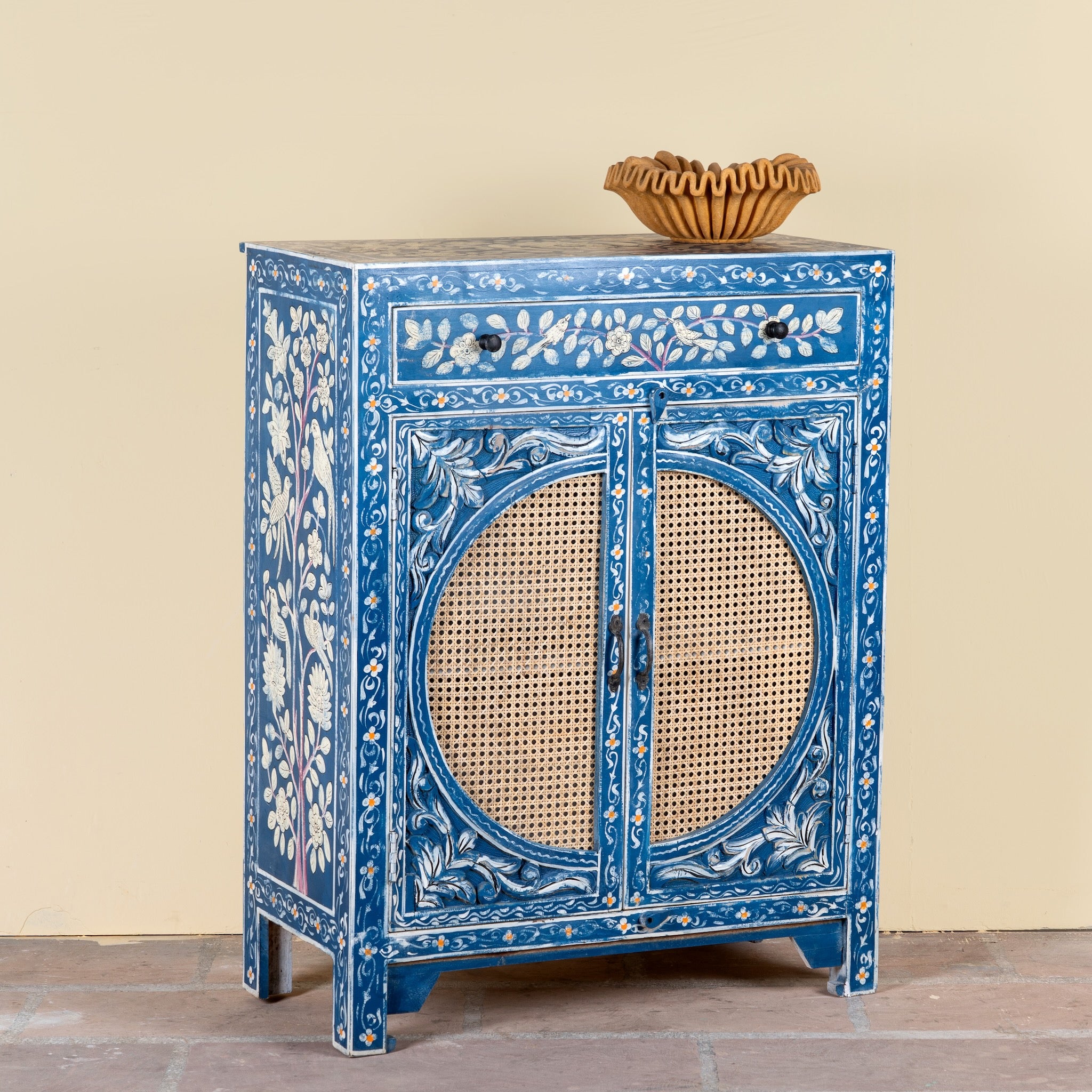 Side angle image of a Satya hand painted reclaimed wood cabinet with natural rattan doors 105cm