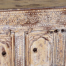 Close up image of a Satyam hand carved reclaimed wood sideboard with four arched doors and distressed cream vintage finish 153cm