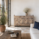 Lifestyle image of a Satyam hand carved reclaimed wood sideboard with four arched doors and distressed cream vintage finish 153cm