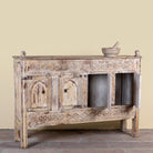 Side angle with open doors image of a Satyam hand carved reclaimed wood sideboard with four arched doors and distressed cream vintage finish 153cm