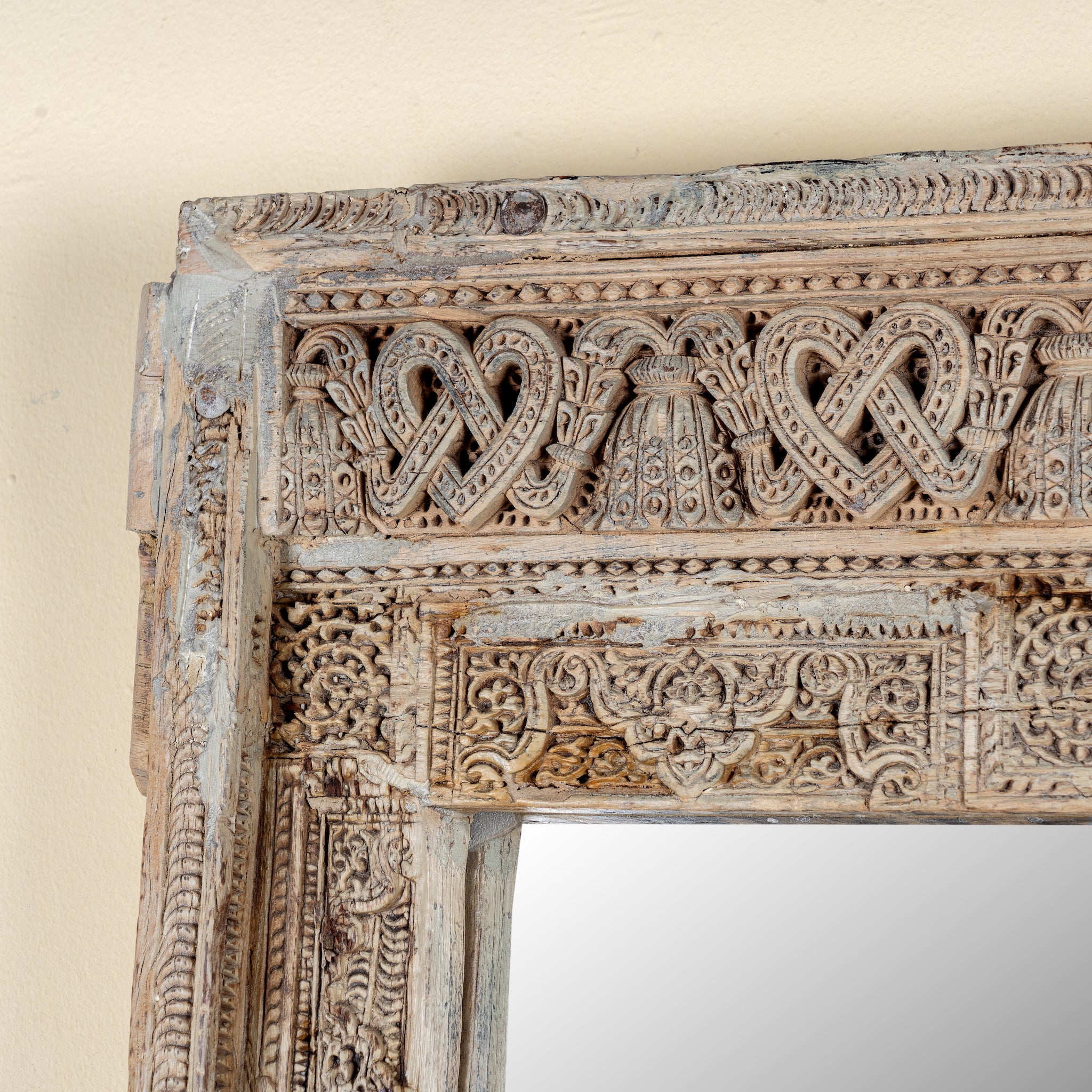 Close up image of a unique antique reclaimed teak wood wall mirror crafted from a hand carved window frame with bleached finish, Shanika 110x15x176cm