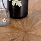 Close up image of a Shankhin mango wood dining table featuring an intricately patterned natural wood tabletop with a brass-plated iron base and contemporary industrial design, 180cm.