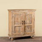 Side angle image of a Sharad hand-carved reclaimed wood cabinet with two carved doors and natural aged wood character.