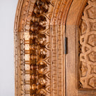 Close up image of a Shivaaya hand carved mango wood cabinet with geometric double doors and arched top 210cm