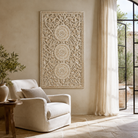 Lifestyle image of a whitewashed hand-carved mango wood wall panel with intricate floral openwork detailing, designed as elegant vertical wall décor with timeless artisan character.