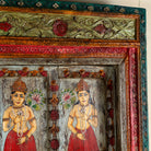 Close up image of an antique Indian teak wood door with hand-painted figures holding lotus flowers, vintage wall panels and vintage home decor.