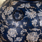 Close up image of a set of 3 round hand-painted iron pots with silver floral designs on blue background, artisanal Indian home accessories and vintage decor accents.
