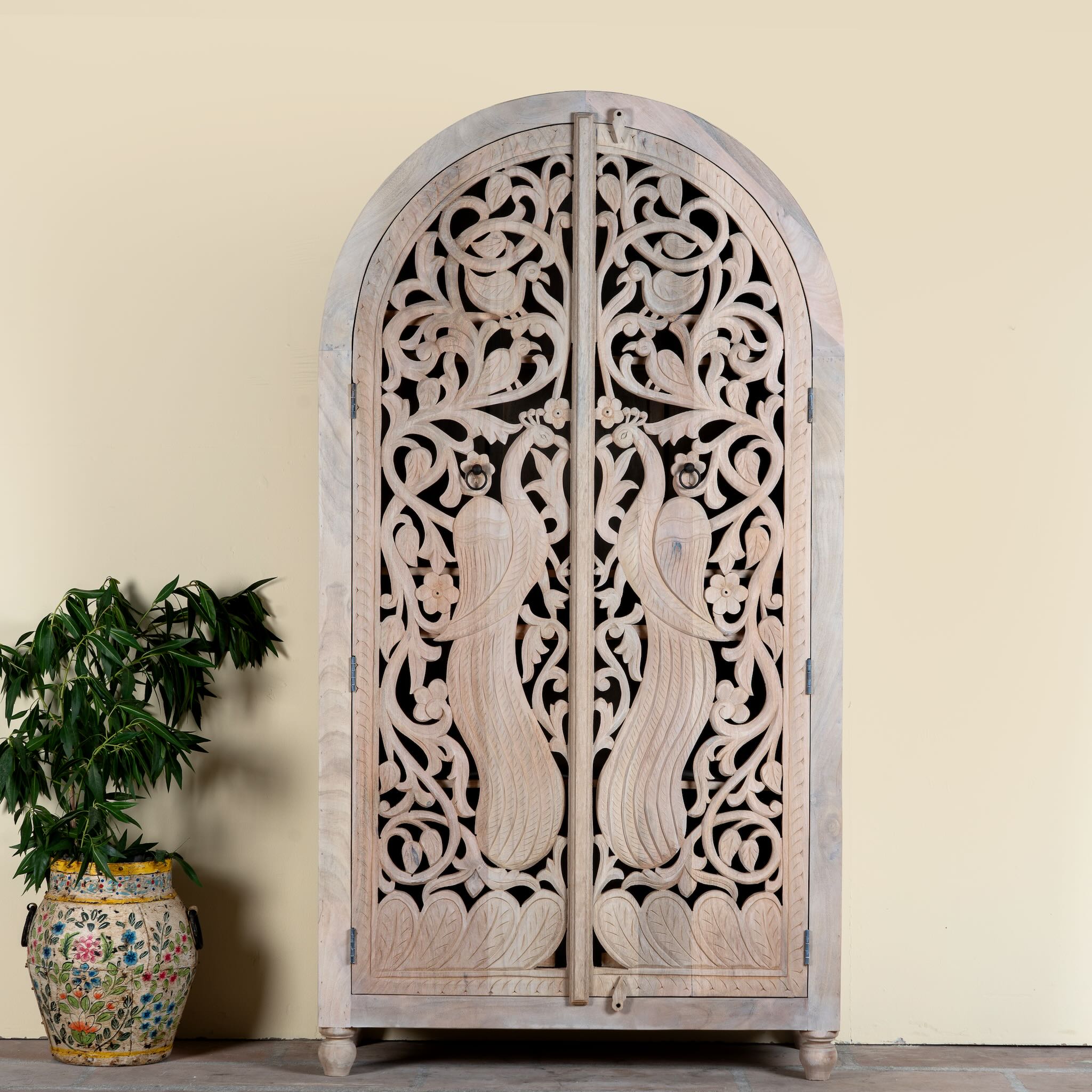 Hand-carved mango wood wardrobe with arched top and intricate peacock floral design – artisanal Indian bedroom furniture.