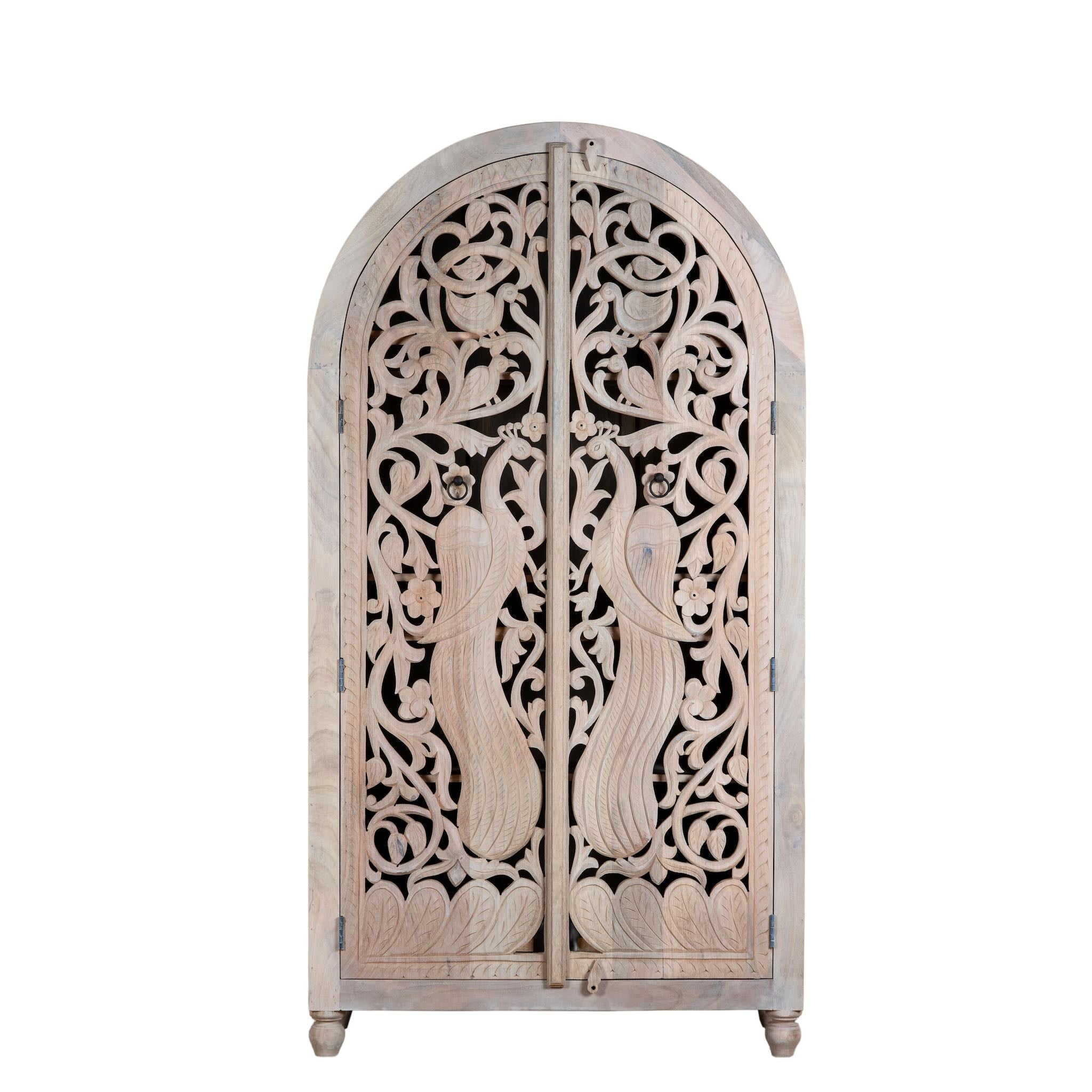 White background image of a hand-carved mango wood wardrobe with arched top and intricate peacock floral design – artisanal Indian bedroom furniture.
