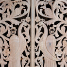Close up image of a hand-carved mango wood wardrobe with arched top and intricate peacock floral design – artisanal Indian bedroom furniture.