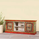 Side angle image of a hand-painted reclaimed wood vintage lowboard with floral motifs – a colourful piece of sustainable furniture for artistic and rustic interiors.