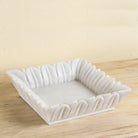 Square hand-carved white marble bowl with petal-like edges – decorative Indian marble accessory.