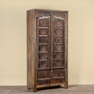 Side angle image of a Srinika vintage Indian wardrobe with mango wood body and old hand-carved teak house door, 94x42x195cm
