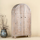 Side angle image of a handcrafted mango wood wardrobe with arched top and floral carving – Tamia by Om Home & Garden, unique furniture with Ibiza-style charm for living rooms and bedrooms.