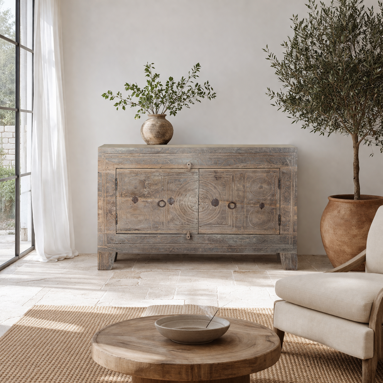 Lifestyle imagination o a handcrafted sideboard Tanay made from reclaimed teak wood, featuring antique Indian door fronts with original carvings. A Mediterranean-inspired piece of unique Indian furniture with sustainable character and functional storage.