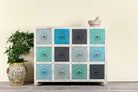 Image of a carved mango wood chest of drawers with twelve multicolour floral drawer fronts, 124 × 40 × 102 cm.