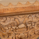 close up image of a Tanira hand carved mango wood wall shelf with floral carvings and decorative hanging leaf details 60cm