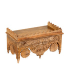 Side angle image of a Tanira hand carved mango wood wall shelf with floral carvings and decorative hanging leaf details 60cm