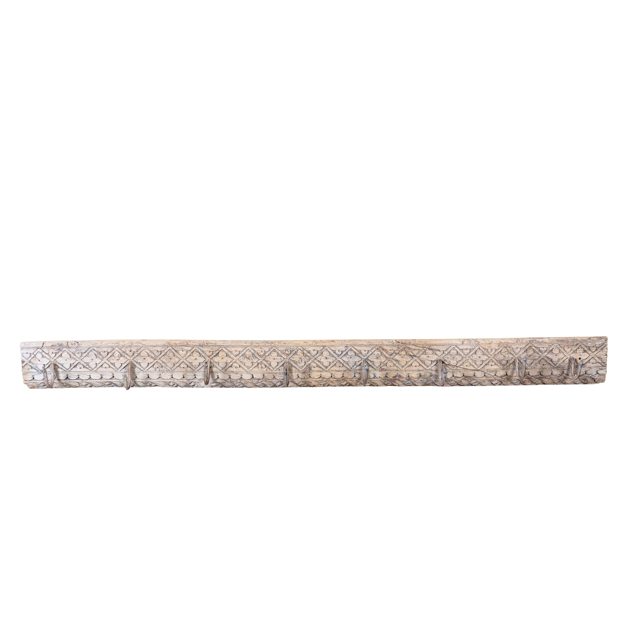 White background image of a Temple Carved Hook Board handcrafted from an antique Indian reclaimed wood architectural element with hand-carved floral details, bleached finish and eight iron hooks, 150x7x5cm.