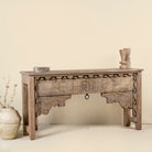 Side angle image of a handcrafted entryway table vintage, unique furniture in reclaimed teak wood with floral and geometric carvings, 160 × 40 × 90 cm.