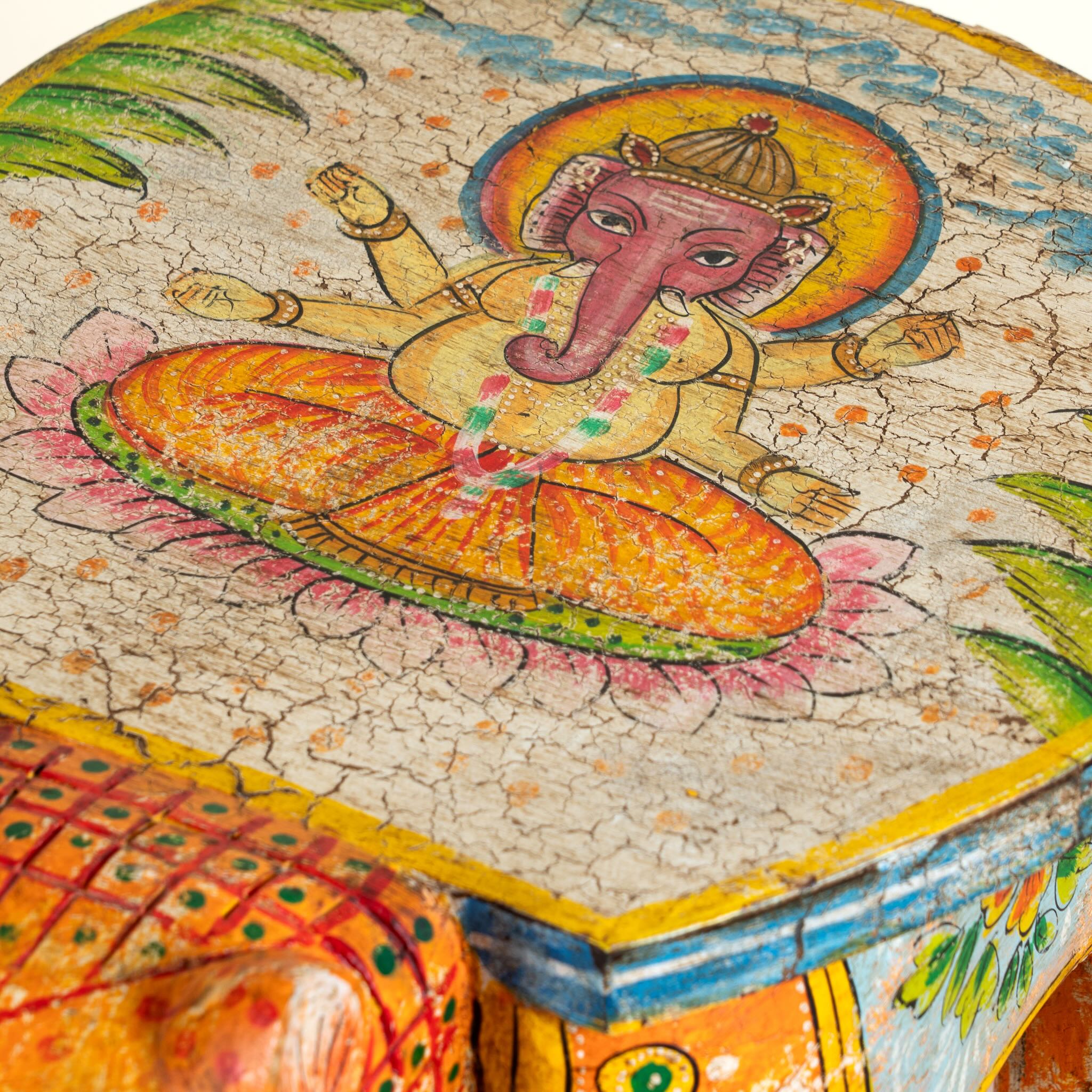 Close up image of a hand-painted wooden tiger side table featuring Indian folk art and floral details, shaped like a tiger with deity painting on top, perfect for vintage and India-inspired home accessories.
