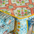 Close up image of a hand-painted wooden tiger side table featuring Indian folk art and floral details, shaped like a tiger with deity painting on top, perfect for vintage and India-inspired home accessories.