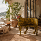 Lifestyle image of a hand-painted tiger chair made from recycled teak wood with carved tiger motif; ideal for a boho chic living room, 87 × 75 × 96 cm.