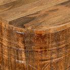 Close up image of a hand-carved mango wood coffee table with barrel shape and warm rustic finish; vintage style coffee table, 45 cm diameter, 55 cm height.