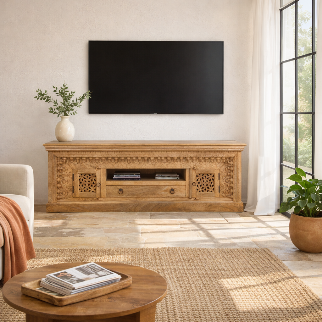 Lifestyle image of a hand carved mango wood TV unit with hand-carved doors, one drawer, and open shelf, 150 × 60 × 40 cm.