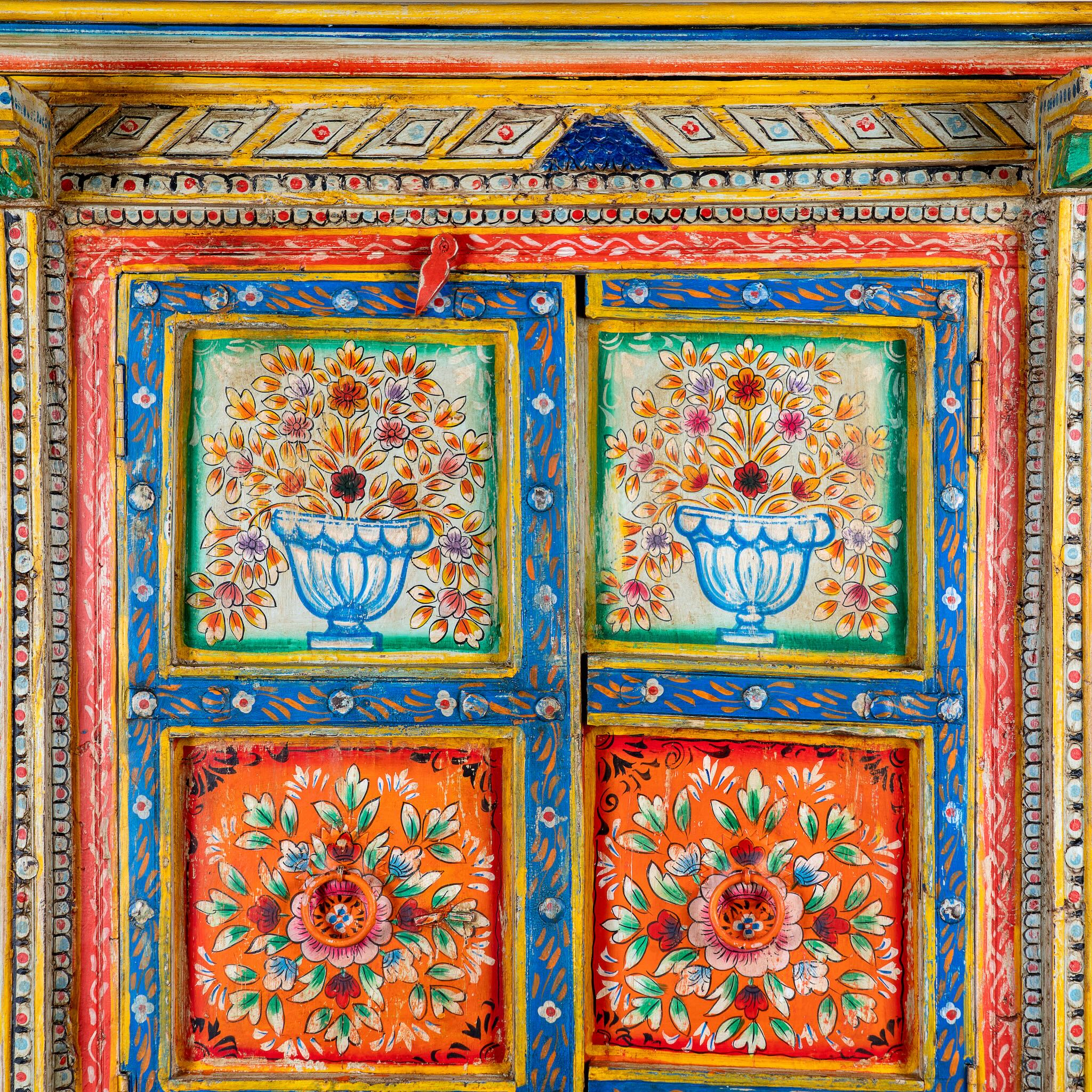 Close up image of a hand-painted teak wood cabinet with floral motifs; teak wood furniture for bohemian interiors, 105 × 55 × 177 cm.