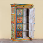 Side angle with open door image of a hand-painted teak wood cabinet with floral motifs; teak wood furniture for bohemian interiors, 105 × 55 × 177 cm.